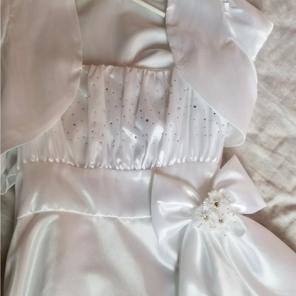 All white first communion dress with design and side bow.